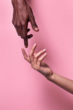 Opposed hands of african-american man pointing at each other wit index finger isolated on pink background