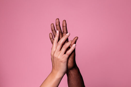 Hands of white woman and black man touching