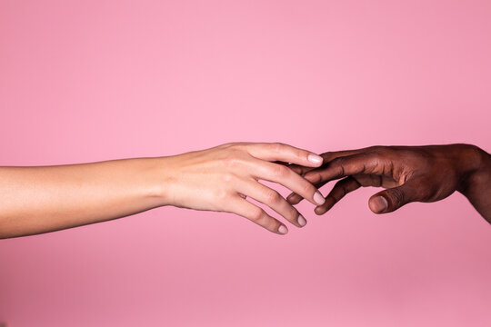 Hands of white woman and black man touching