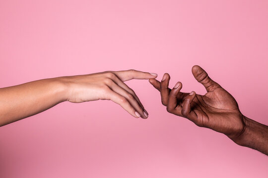 Hands of white woman and black man touching