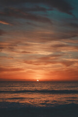 Naklejka na ściany i meble A sunrise over a beach.