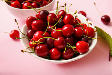 Bowl with tasty ripe cherry on color background, closeup
