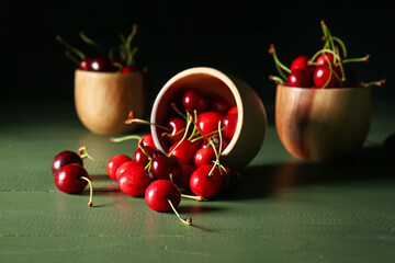 Bowls with tasty ripe cherry on dark background