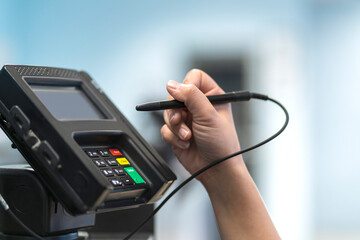 closeup female hand sign and pay money by credit card cashier counter cashless business payment process business ideas concept with abstract blur image background copyspace