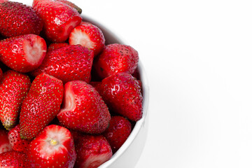 Fresh ripe strawberries in a white vase close-up on a white isolated background. Place for an inscription.