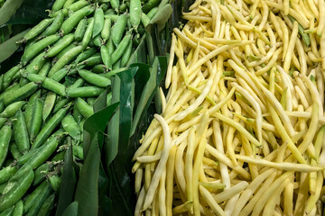 Fresh green peas and butter beans piled on the market. Food background. Harvest