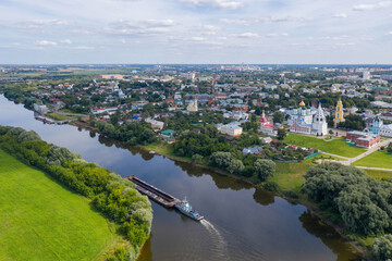 Aerial view of a barge drifting on Moscow river passing by historical part of the town.  Kolomna, Moscow Oblast, Russia.