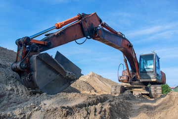 Excavator stands on a pile of sand. Kolomna, Moscow Oblast, Russia.