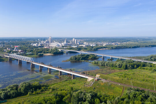 Aerial view of Oka river, bridges and Shchurovsky cement plant Holcim at sunny day. Kolomna, Moscow Oblast, Russia.