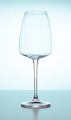 Elegant empty crystal glass for red or white wine on a white background with reflections. Glassware, bars, restaurants, beverages, lifestyle.