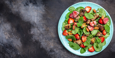 Fresh strawberries, spinach salad with chicken liver, almond and mint. Healthy fats, clean eating for weight loss. Long banner format. top view