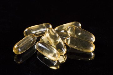 gold fish oil capsules on white background