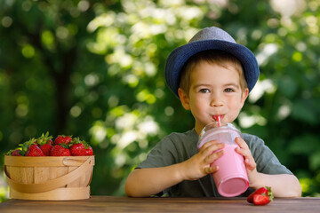 little boy drinking strawberry milkshake from disposable plastic glass