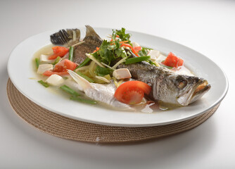 steamed fresh whole grouper fish with beancurd, tomato, sour vegetable and ginger in teo chew style asian halal menu