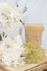 Still life with an old book, a cup of coffee and chrysanthemum flowers