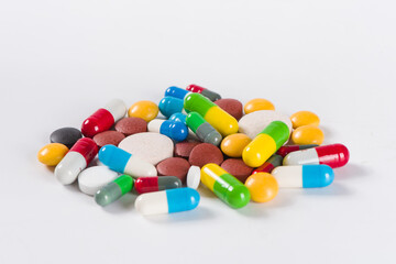 Assorted pharmaceutical medicine pills, tablets and capsules on white background