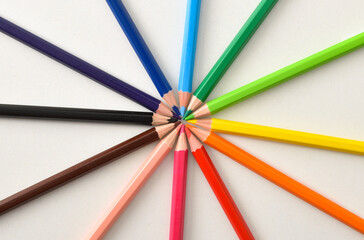 Naklejka premium Color pencils on circle on white table top view
