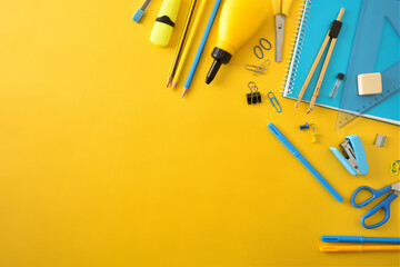 Yellow and blue school supplies on yellow top diagonal composition