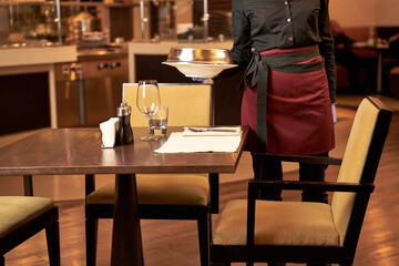 Person lowering a covered dish on a table with cutlery