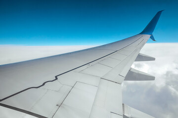 Fototapeta premium View from the window of a passenger plane above the clouds. International cargo transportation, air travel, transport, air travel, vacations. Copy space.