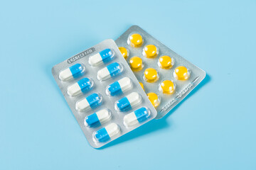 blue ande yellwo capsule pills in blister package.