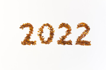 2022 written by natural amber stones on white background