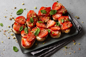 Bruschetta with fresh strawberries, pistachio and mint