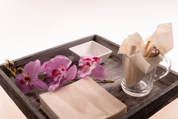 Wooden tray with white bowl and orchid isolated