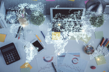 Social network hologram drawings over computer on the desktop background. Top view. Multi exposure. Concept of people connection.