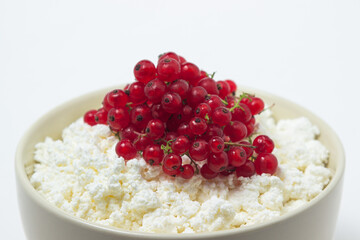 Cottage cheese with red currants on a white plate. Delicious and healthy breakfast. Proper nutrition