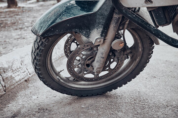 Front wheel of Off road enduro motorcycle. The city, urban landscape, asphalt and stones. Concept of travel, leisure sports and hobbies. Close up shot