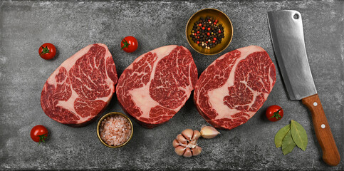Close up three raw beef ribeye steaks on table