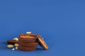 Sweet peanut butter cups on blue background. Space for text