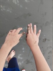 the child is playing sand with hands at beach design for development of joy