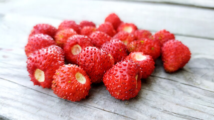 Strawberries on a wooden background close-up. Ripe red berries lie in a heap on the table. Delicious aromatic berries.