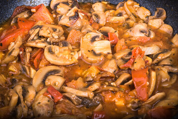 Healthy vegetarian dish with vegetable protein - mushrooms in tomato and onion sauce, close-up