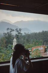A girl try to take photo  in the morning with mountain view