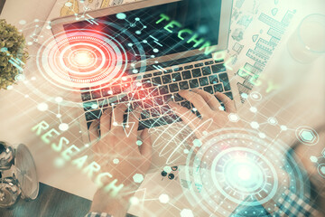 Multi exposure of man's hands typing over computer keyboard and data theme hologram drawing. Top view. Technology concept.