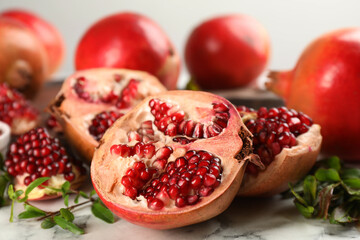 Delicious ripe pomegranates on white table, closeup