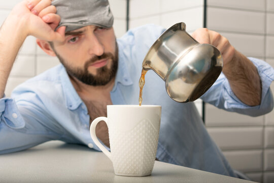 Man takes off his sleep mask and pours a refreshing morning coffee, close-up, cropped image, close-up