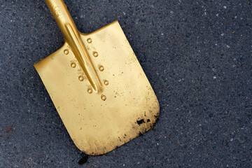A golden shovel is lying on the asphalt.Opening Ceremony