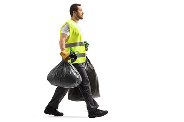Full length profile shot of a garbage man walking and carrying bin bags