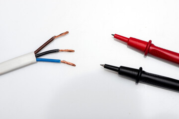 Electronic digital multimeter isolated on white with probes. Digital multimeter with red and black leads. Electronic multimeter isolated on white background close up