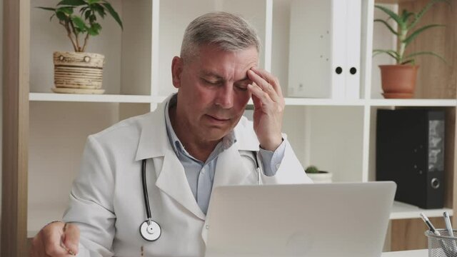 Overworked Doctor During Hard Office Work, Senior Man In Front Of Monitor