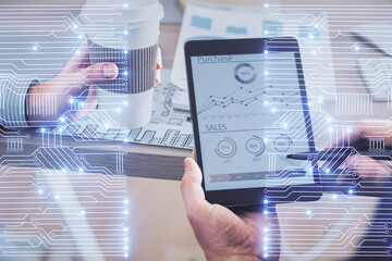Double exposure of man's hands holding and using a digital device and tech theme hologram drawing....