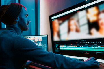 Attractive Male Video Editor Works with Footage or Video on His Personal Computer, he Works in...