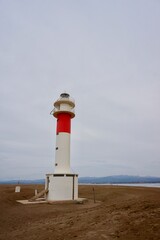 Fototapeta premium Delta del Ebro. Tarragona. Spain. 06/20/2021. lighthouse with people and sand and blue sky