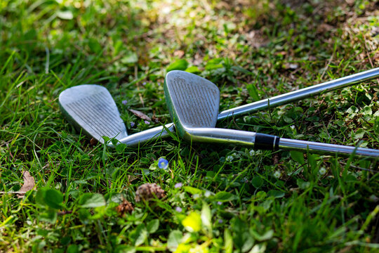 view of two golf clubs on grass