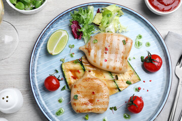 Grilled squid tubes served on white wooden table, flat lay