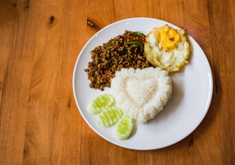 Stir Fried Pork with Curry Paste on Rice. Add fried eggs, decorate the dish with cucumber.